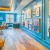 a room with a wood floor with art on the wall