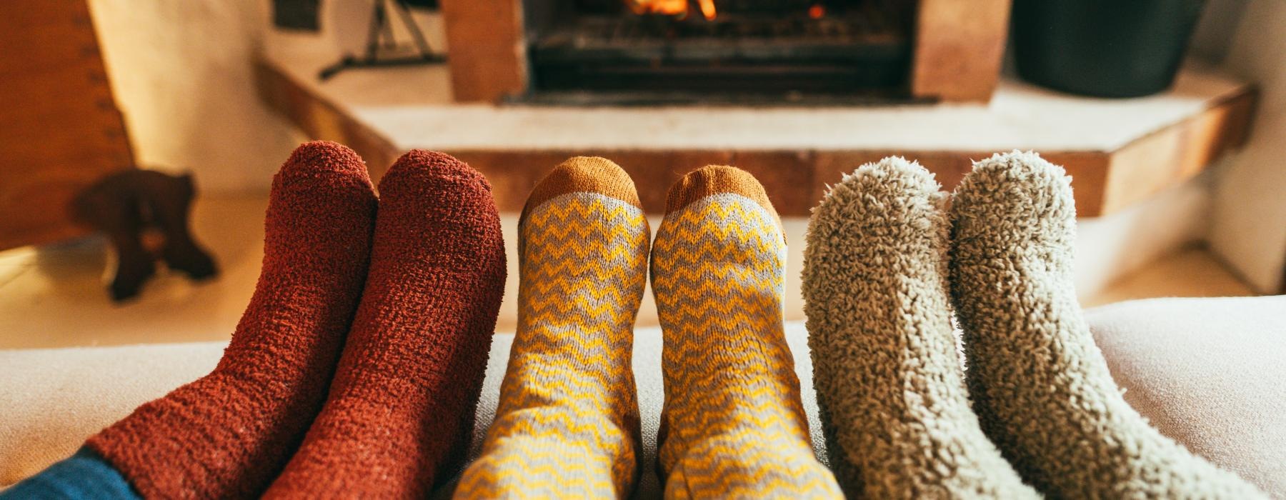 a pair of feet in front of a fireplace